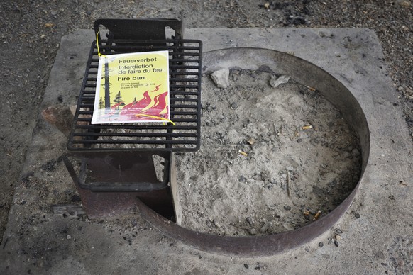 KEYPIX - Eine Grillstelle in einem Schweizer Seebad ist gesperrt. Ein gelbes Warnschild weist auf das absolute Feuerverbot hin, fotografiert am Dienstag, 14. Juli 2026 in Sutz Lattrigen. Wegen der anh ...
