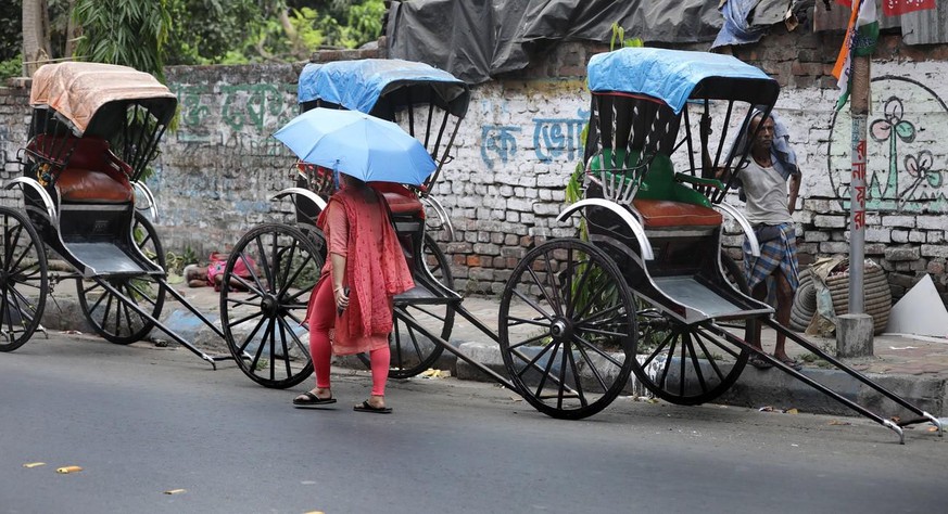 Des tireurs de rikshaw attendent pendant une chaude après-midi à Kolkata, dans l'est de l'Inde, le 19 avril 2022.
