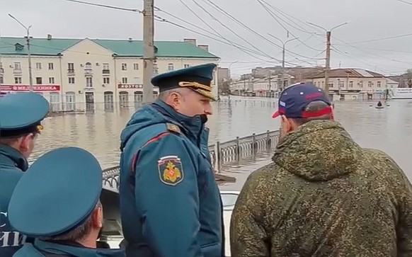 epa11263753 A photo taken from a handout video made available by the Russian Emergency Situations Ministry shows Russian Emergencies Minister Alexander Kurenkov (C) inspects the flood zone in Orsk, Or ...