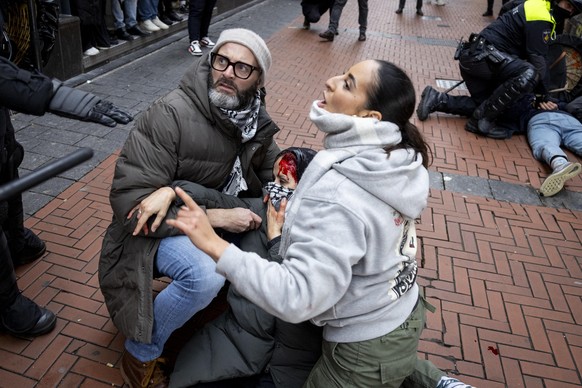 epa11713194 People assist a bloodied pro-Palestinian protester near Dam Square in Amsterdam, the Netherlands, 10 November 2024. The protest took place while an emergency ordinance and demonstration ba ...