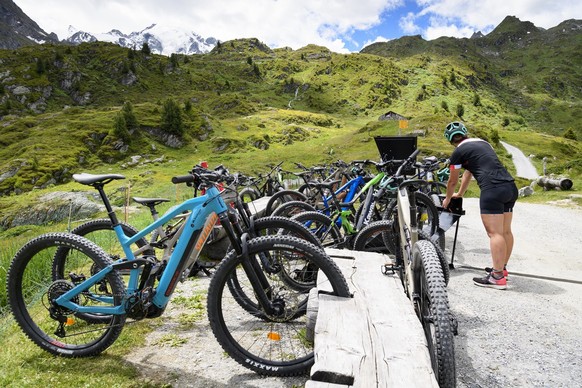 People taking a break and charging their E-Bike (Mountainbike) at the &quot;Cabane Marcel Brunet&quot; during a press tour of the &quot;discovery trail&quot;, backdroped of mountains of the Swiss Alps ...