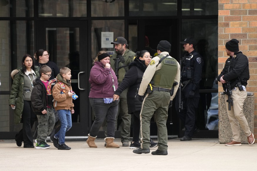 People leave the McCreary Community Building after being reunited following a shooting at Perry High School, Thursday, Jan. 4, 2024, in Perry, Iowa. (AP Photo/Charlie Neibergall)