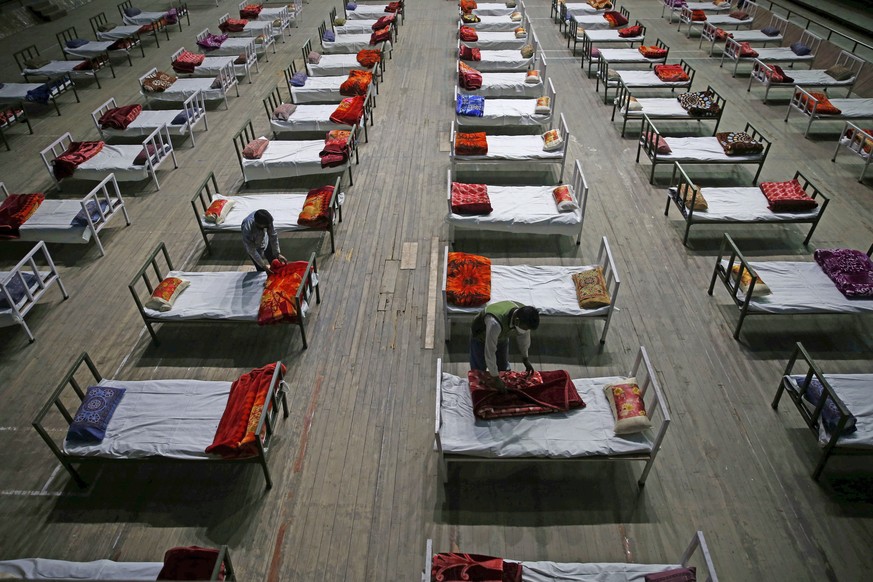 epa09163568 Workers work during preparations to convert an indoor stadium into Covid-19 centre for emergencies in the wake of the spike in the numbers of positive coronavirus cases, in Srinagar, the s ...