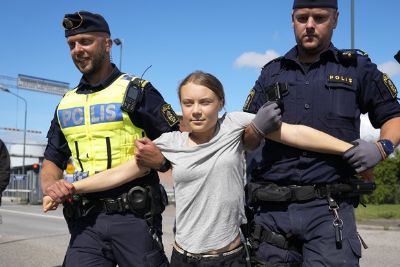 Climate activist Greta Thunberg is detained by police during an action for blocking the entrance to an oil facility in Malmo, Sweden, Monday, July 24, 2023. The protest took place just a few hours aft ...