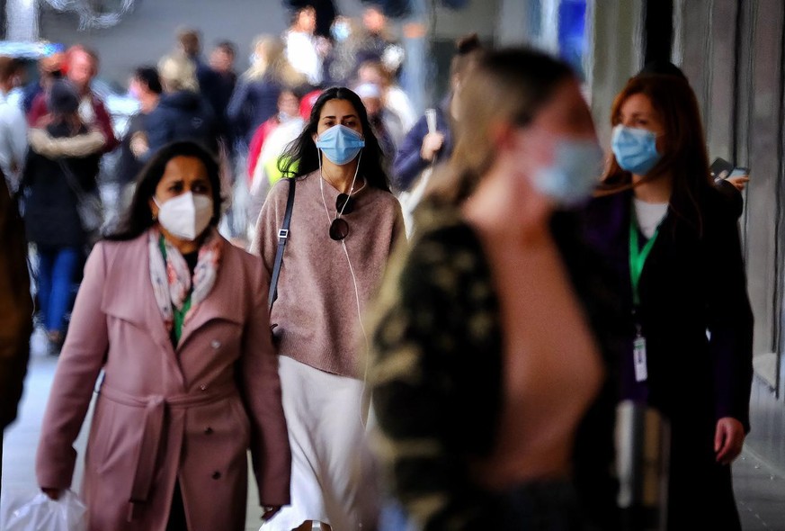 epa09345248 People wearing face masks walk in the CBD of Melbourne, Victoria, Australia, 15 July 2021. Victoria has reported two new locally acquired COVID-19 cases, on top of the 10 reported in Thurs ...