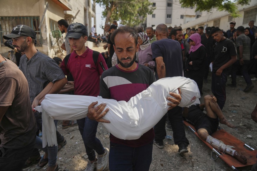 A Palestinian man carries the body of his 7-year-old nephew, Alaa Al-Toum, who, according to the family, was killed in an Israeli army airstrike last night, during his funeral at Shifa Hospital in Gaz ...