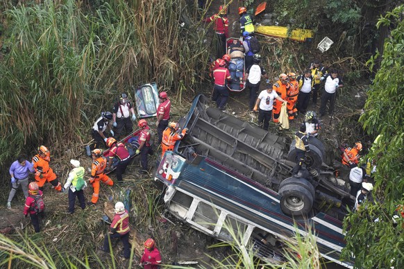 Firefighters work at the scene of a bus that fell from a bridge on the outskirts of Guatemala City, Monday, Feb. 10, 2025. (AP Photo/Moises Castillo)