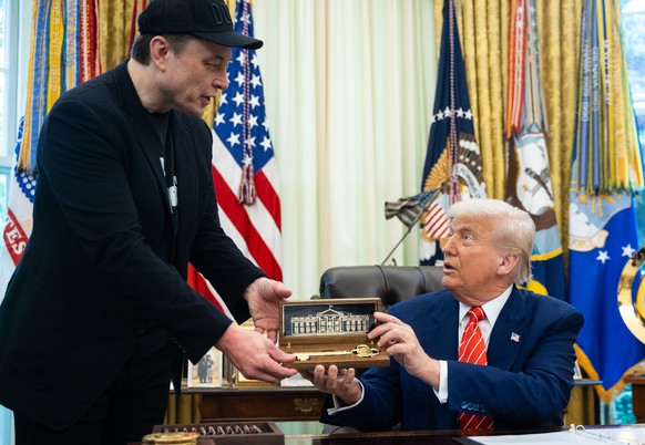 epa12145972 Elon Musk receives a gift from US President Donald Trump (R) during a press conference in the Oval Office at the White House in Washington, DC, USA, 30 May 2025. EPA/FRANCIS CHUNG / POOL