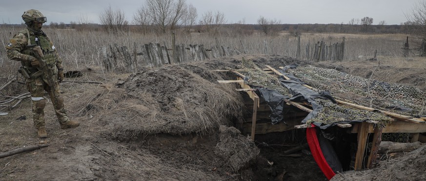epa09853585 Russian serviceman examine the position of a Ukrainian army dugout inside the village of Trokhizbenka, Luhansk region, Ukraine, 27 March 2022. On 24 February Russian troops had entered Ukr ...