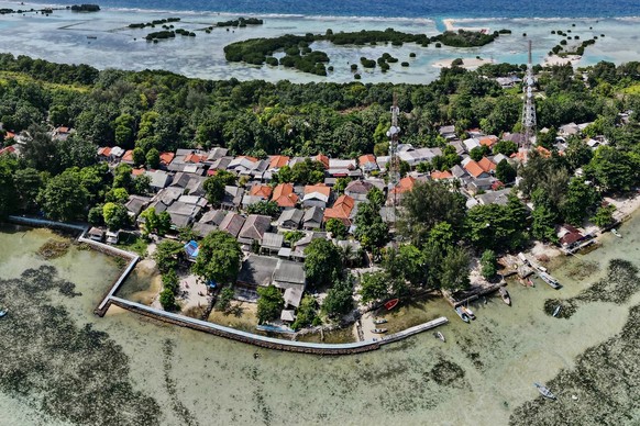 (FILES) In this aerial picture taken on February 22, 2023, a concrete embankment, used to stem rising sea levels, is seen around part of Pari island in the Thousand Islands cluster. More than two year ...