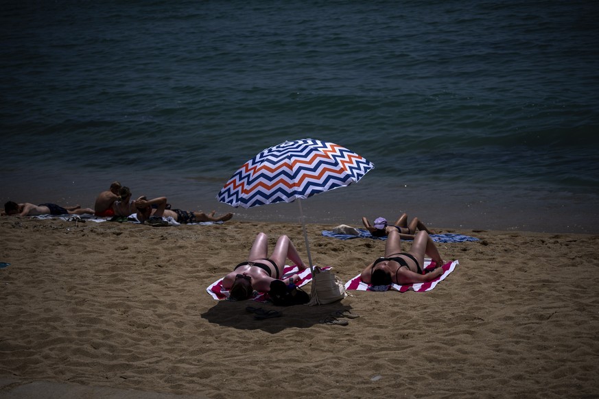 People sunbathe on a beach in Barcelona, Spain, Monday, July 17, 2023. Spain&#039;s Aemet weather agency said a heatwave starting Monday &quot;will affect a large part of the countries bordering the M ...