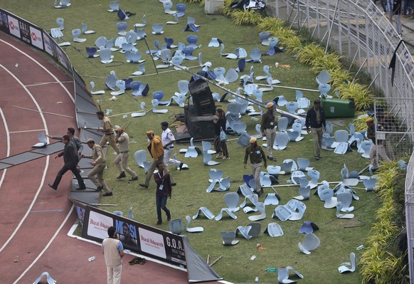 epa12589079 Police officers try to stop Messi fans as they throw bottles and chairs, vandalising hoardings at Salt Lake Stadium in Kolkata, India, 13 December 2025. Following Messis brief five-minute ...