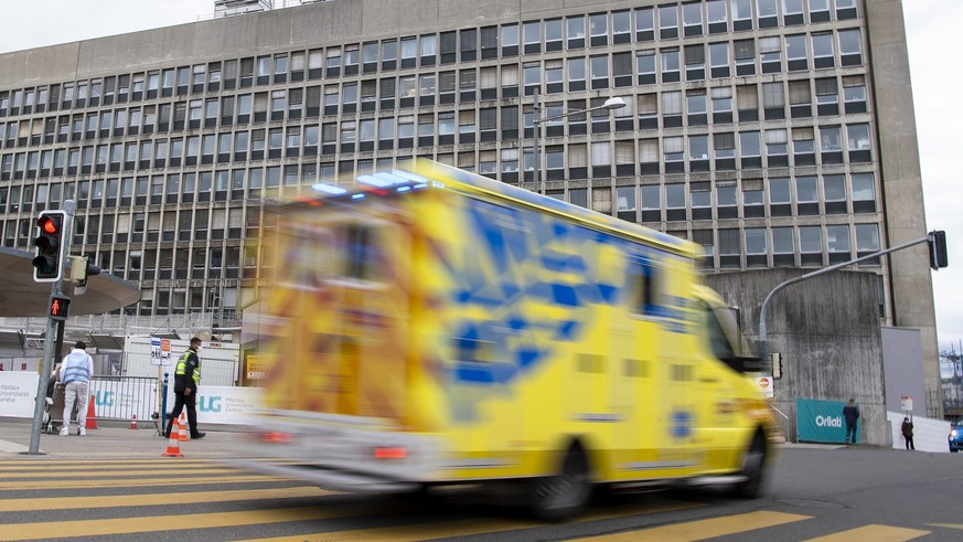 Une ambulance roule en urgence avec ses gyrophares enclenches en direction des Hopitaux universitaires de Geneve (HUG), ce jeudi 11 mars 2021 a Geneve. (KEYSTONE/Martial Trezzini)