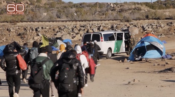 Eine Gruppe Migranten nähert sich einem Fahrzeug der Grenzpatrouillen.