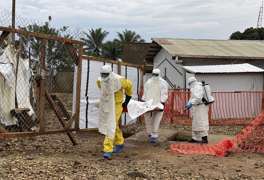 Des agents de santé préparent le corps d'une victime d'Ebola pour l'enterrer dans un centre de traitement à Beni, province du Nord-Kivu, en République démocratique du Congo.