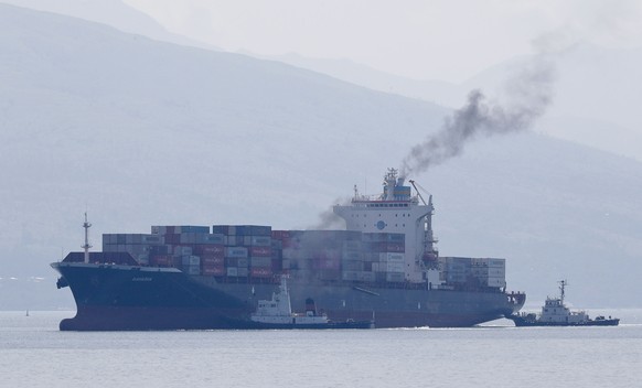 FILE - Cargo ship M/V Bavaria is assisted by tug boats as it prepares to dock at Subic port in Zambales province, northwestern Philippines on Thursday, May 30, 2019. The head of the United Nations cal ...