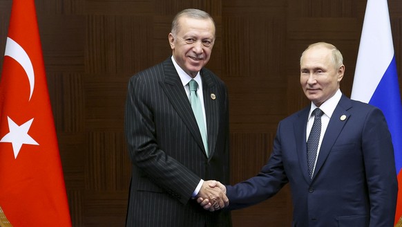 Russia&#039;s President Vladimir Putin, right, and Turkey&#039;s President Recep Tayyip Erdogan shake hands during their meeting on sidelines of the Conference on Interaction and Confidence Building M ...