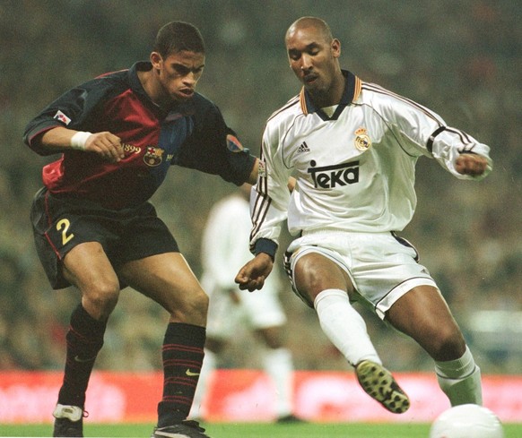 Real Madrid&#039;s French striker Nicolas Anelka, right, struggles for the ball against F.C. Barcelona&#039;s Dutch player Michael Reiziger during a Spanish league soccer match in Madrid Saturday Febr ...