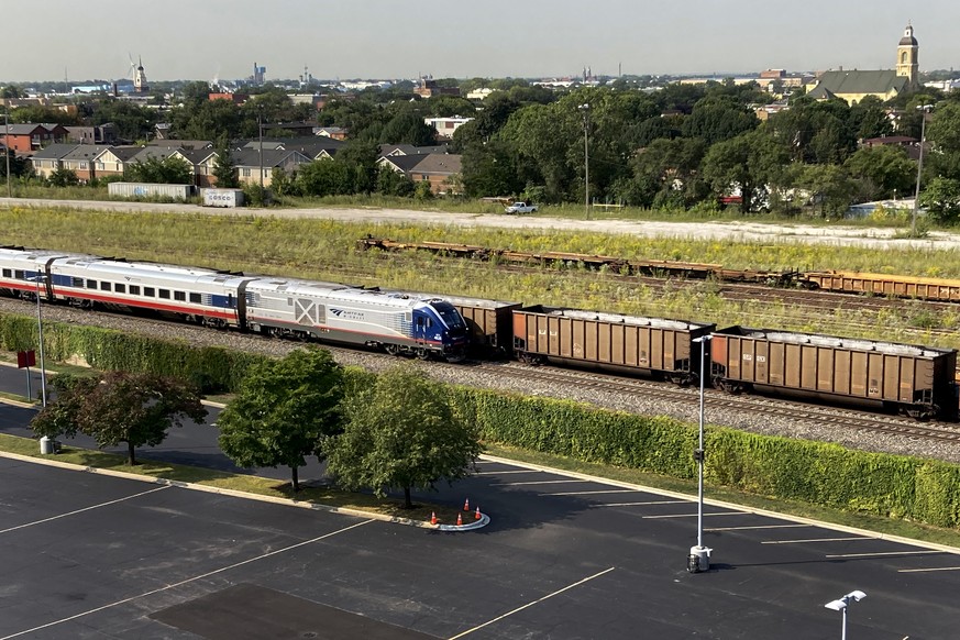 An Amtrak passenger train and a freight train head northbound towards downtown Chicago Wednesday, Sept. 14, 2022, in Chicago. Business and government officials are preparing for a potential nationwide ...