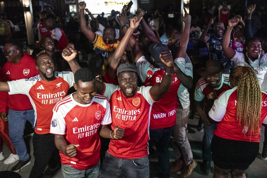 Kenyan fans of Arsenal FC react following their teams victory during a live broadcast of the clubs UEFA Champions League semi-final match against Atletico Madrid in Nairobi on May 5, 2026. In the wa ...
