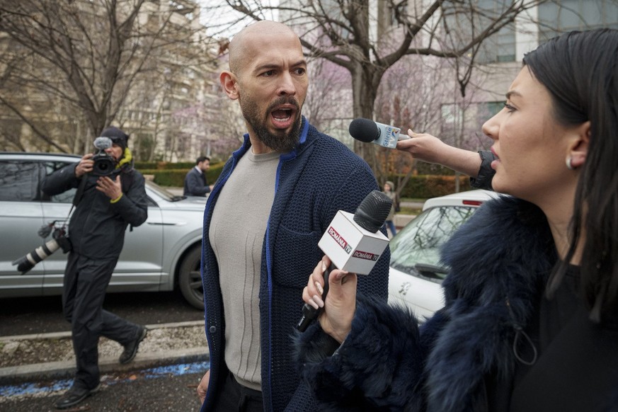 Andrew Tate speaks to a reporter after leaving the Bucharest Tribunal in Bucharest, Romania, Friday, March 15, 2024. A court in Romania&#039;s capital on Wednesday extended geographical restrictions a ...