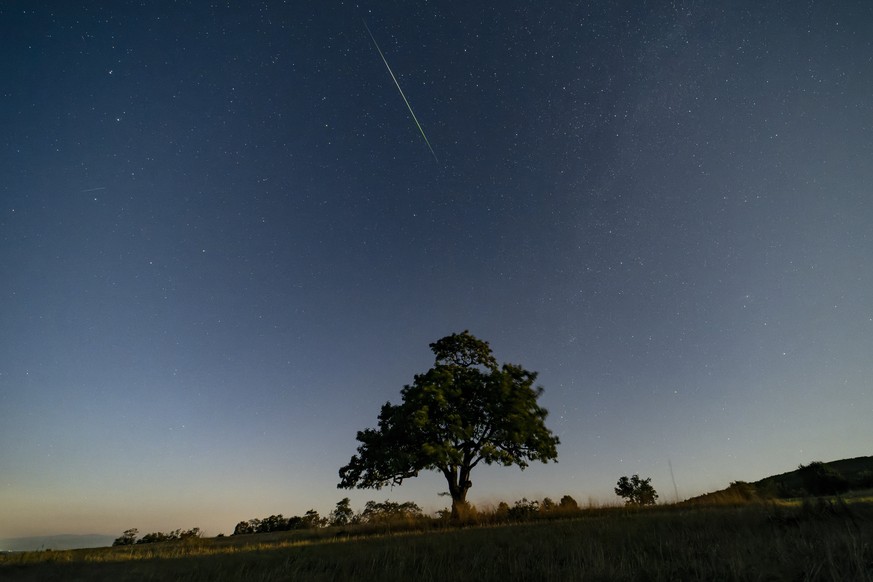 epa12294790 A view of a shooting star during the Perseids meteor shower near Salgotarjan, northern Hungary, 11 August 2025. The Perseids meteor shower occurs every year, peaking in August when the Ear ...
