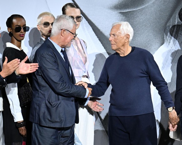 epa11614680 Italian designer Giorgio Armani (C) greets the audience with Leo dell&#039;Orco (L), head of the Armani men&#039;s style office, at the end of the presentartion of his Emporio Armani Sprin ...