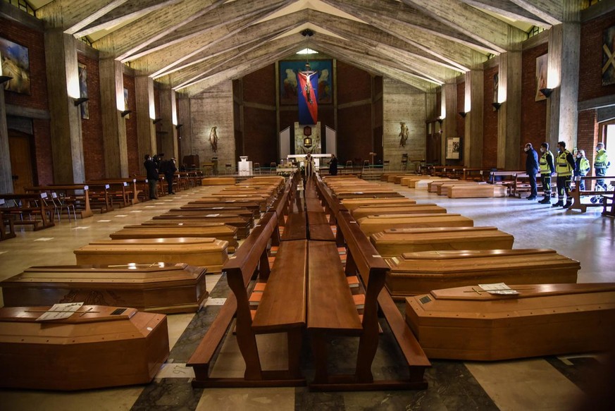 epa08328228 Coffins of people deceased from the COVID-19 novel coronavirus are being blessed inside the church of San Giuseppe in Seriate, Italy, on March 28, 2020. Italy is the country with the highe ...