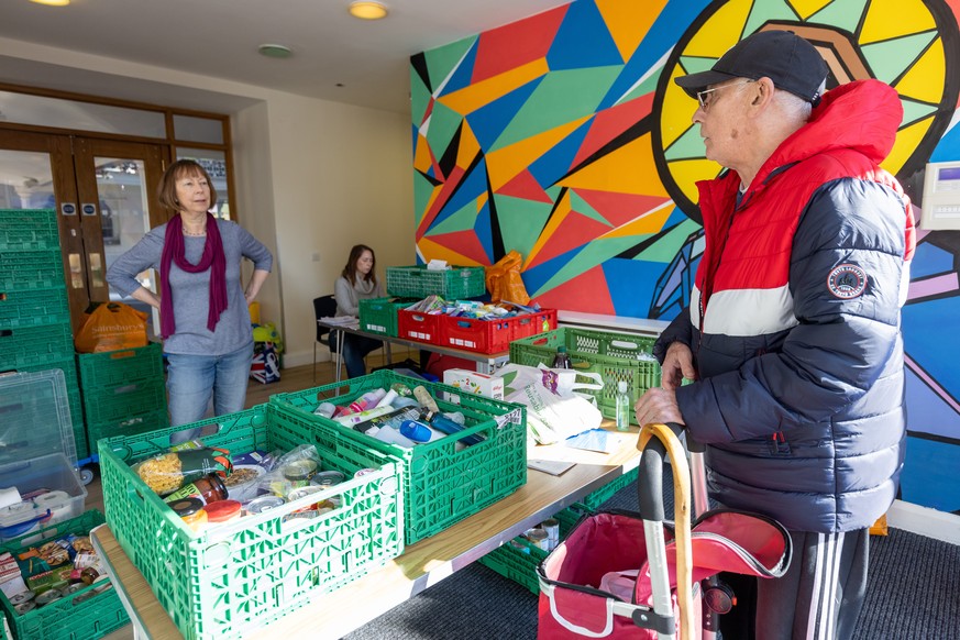 epa09810178 John Pearson (R) collects food from Kingston Food Bank in Everyman Church in Kingston, London, Britain, 08 March 2022. A Food Standards Agency survey published in January 2022 found that b ...