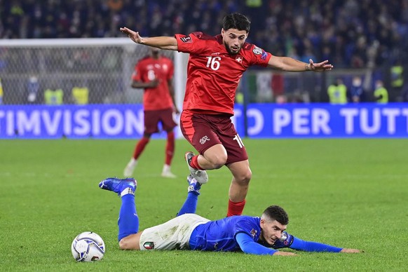 Switzerland&#039;s midfielder Kastriot Imeri, in red, fights for the ball against Italy&#039;s defender Giovanni Di Lorenzo, in blue, during the 2022 FIFA World Cup European Qualifying Group C match b ...