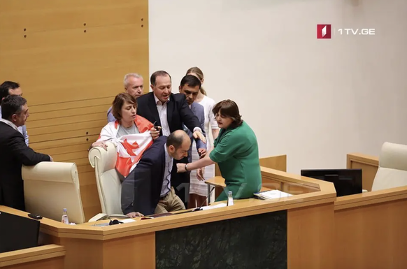 La politicienne de l&#039;opposition Helen Khoshtaria, avec le drapeau géorgien autour de ses épaules, expulse un Russe du parlement.