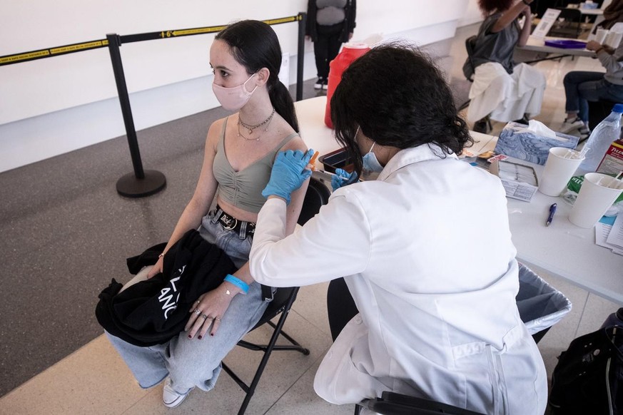 epa09198574 A 14-year-old girl receives a dose of COVID-19 vaccine during a vaccination drive organized by the Annenberg Foundation and Mickey Fine Pharmacy for teenagers aged between 12 and 15 at the ...