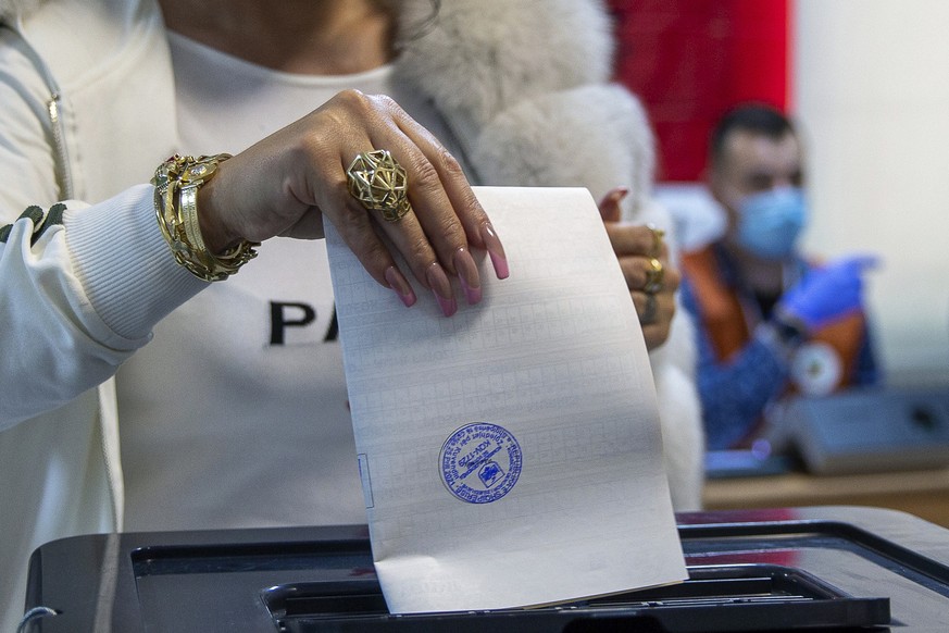 A woman casts her ballot during parliamentary elections in capital Tirana, Albania, Sunday, April 25, 2021. Albanians are voting in parliamentary elections amid the virus pandemic and a bitter politic ...