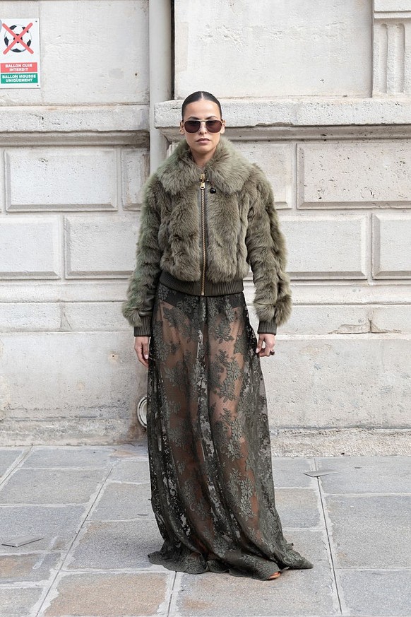 BERLIN, GERMANY - DECEMBER 10: Sonia Lyson is seen wearing black, oval-shaped Vehla sunglasses. Her outfit is cream-colored, consisting of a long, oversized faux fur coat that reaches her ankles. Unde ...