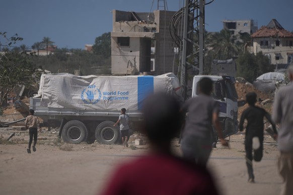 Palestinians rush toward trucks carrying aid from the World Food Programme (WFP) as they drive through Deir al-Balah in central Gaza, Wednesday, Oct. 15, 2025. (AP Photo/Abdel Kareem Hana)
APTOPIX Isr ...