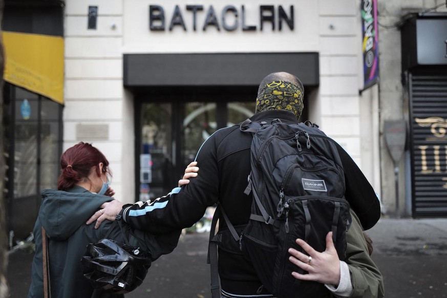 Relatives pay respect outside the Bataclan concert hall marking the 5th anniversary of the Nov. 13, 2015 attacks, in Paris, Friday, Nov. 13, 2020. In silence and mourning, France is marking five years ...