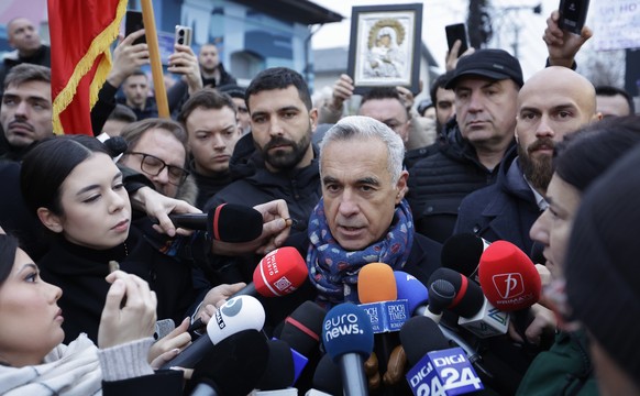 epa11764107 Calin Georgescu, Romania&#039;s independent presidential candidate who won the first round of presidential elections, talks to the media outside the Secondary School No. 1 polling station, ...