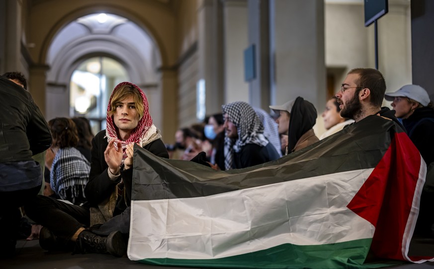 Pro-Palestinian demonstrators holding a Palestinian flag protest in the entrance hall of the main building of the ETH Zurich on Tuesday, May 7, 2024 in Zurich, Switzerland. (KEYSTONE/Michael Buholzer)