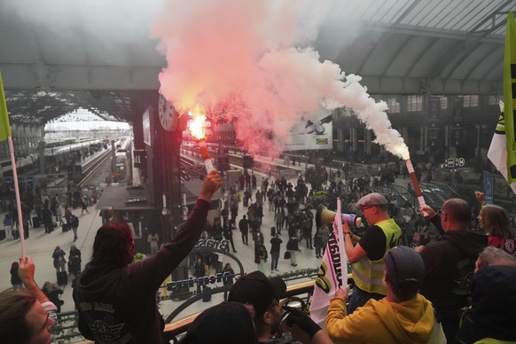 FILE- Railway workers hold smoke bombs in the Gare de Lyon train station, during the « Bloquons Tout » (Block Everything) protest movement in Paris, France, Wednesday, Sept. 10, 2025. (AP Photo/Thibau ...