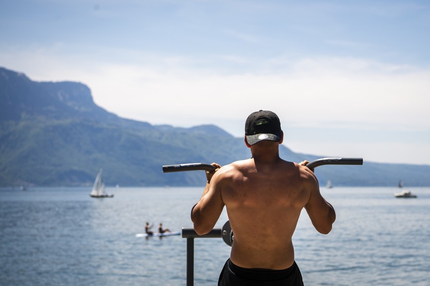 Une personne fait de la musculation sur une machine en regardant les montagnes et le lac Leman le dimanche 30 mai 2021 a Vevey. (KEYSTONE/Jean-Christophe Bott)