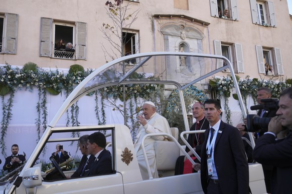 Pope Francis greets faithful after praying in front of the statue of the Virgin Mary in Ajaccio on the occasion of his one-day visit in the French island of Corsica, Sunday, Dec. 15, 2024. (AP Photo/A ...