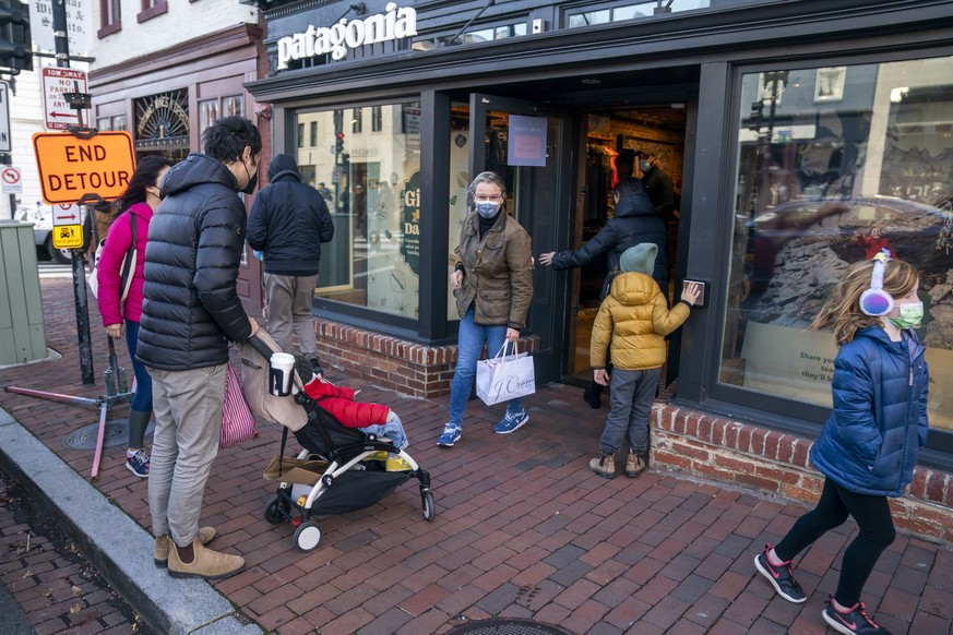 epa09605580 Shoppers exit the Patagonia store during Black Friday shopping in the Georgetown District of Washington, DC, USA, 26 November 2021. Despite concerns about COVID-19, supply chain bottleneck ...