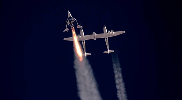 epa09339457 A framegrab from a video made available by Virgin Galatic shows SpaceShip Two Unity 22 under thrust heading towards space after separating from the carrier plane (R) above Spaceport Americ ...