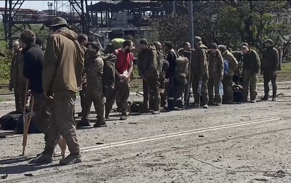 epa09956596 A still image taken from a handout video dated 17 Apirl 2022 and made available by the Russian Defence ministry press service on 18 April 2022 shows Ukrainian servicemen from the besieged  ...
