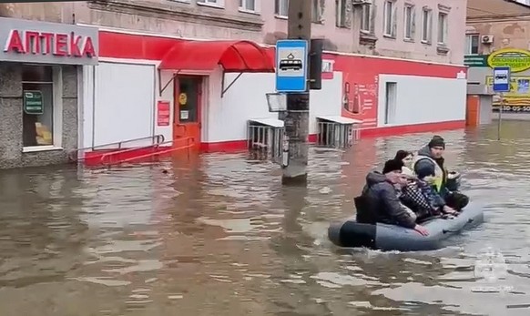 epa11263755 A photo taken from a handout video made available by the Russian Emergency Situations Ministry shows residents in a boat on a flooded street in Orsk, Orenburg region, Russia, 07 April 2024 ...