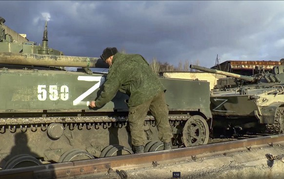 epa09829115 A handout still image taken from handout video made available by the Russian Defence ministry press-service shows a Russian soldier marks an armoured personnel carrier that was abandoned b ...