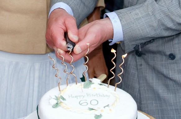 BROMHAM, UNITED KINGDOM - JULY 17: (EMBARGOED FOR PUBLICATION IN UK NEWSPAPERS UNTIL 24 HOURS AFTER CREATE DATE AND TIME) Prince Charles, Prince of Wales lights (using a cigarette lighter) the candles ...