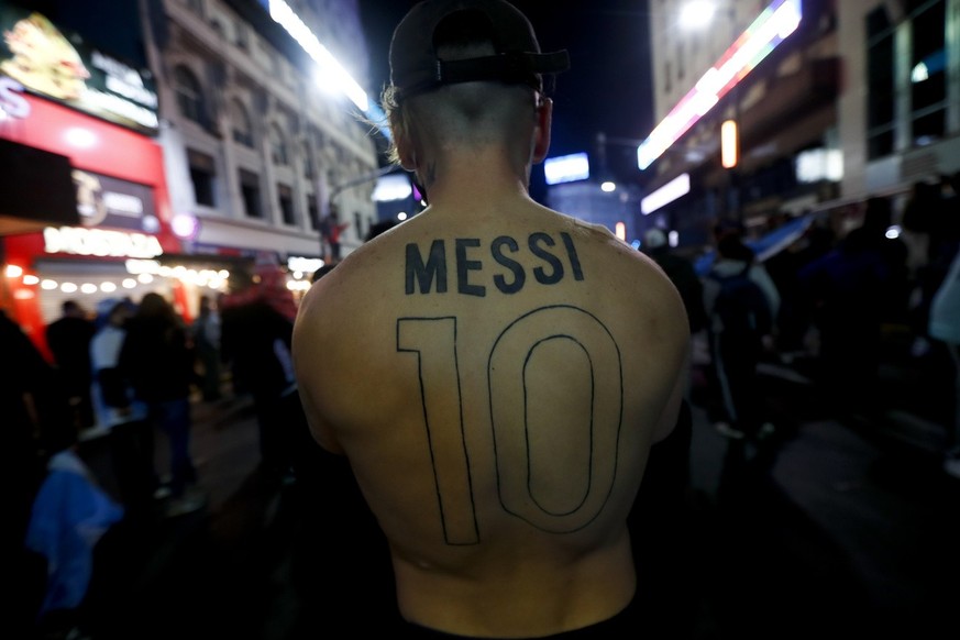 An Argentina&#039;s fan with a tattoo of Argentina&#039;s Lionel Messi name written on his back gathers to celebrate winning the Copa America final soccer match against Brazil in Buenos Aires, Argenti ...
