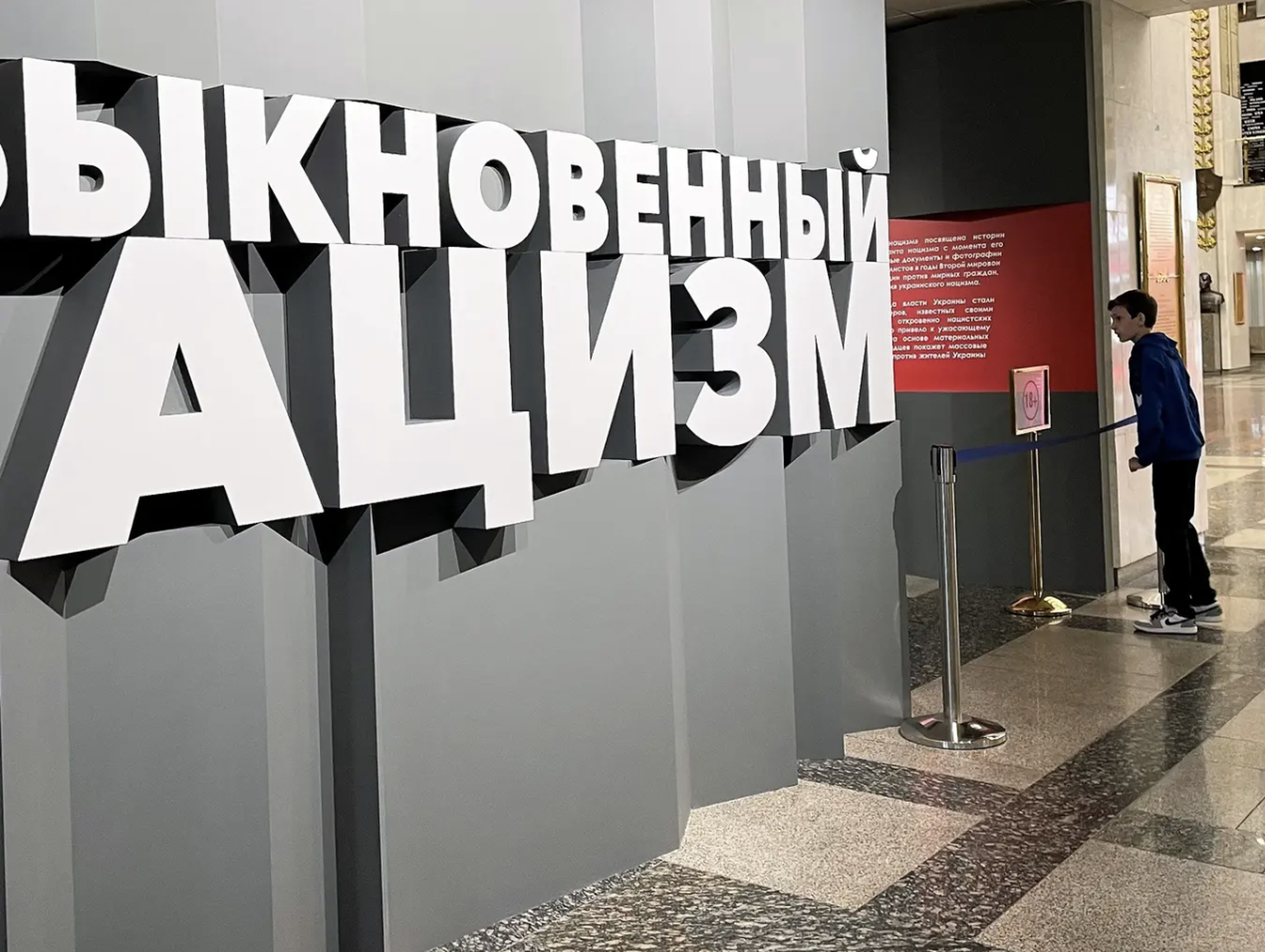 Un garçon regarde furtivement dans la salle d&#039;exposition à Moscou. Elle est intitulée &quot;Le nazisme ordinaire&quot;. Une exposition veut y montrer depuis quelques semaines à quel point l&#039; ...