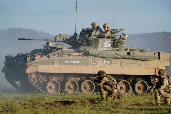 SALISBURY, ENGLAND - NOVEMBER 23: Prince William, Prince of Wales, Colonel-in-Chief, 1st Battalion Mercian Regiment (L) listens to a briefing ahead of an attack exercise during a visit to the regiment ...